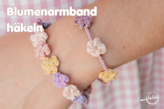 häkelblumen auf Armband auf Handgelenk sommerliche Farben rosa-lila