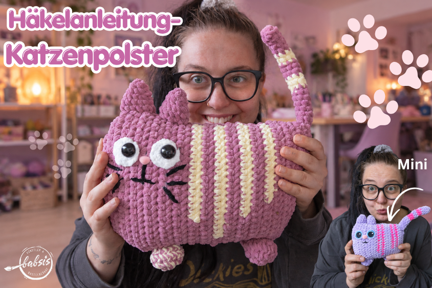 Häkelanleitung Katzenpolster: Frau präsentiert eine große altrosa Chenillekatze und eine helllila Mini-Variante
