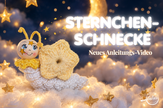 Sternchenschnecke mit gelbem Sternenhaus und weißem Häkelkörper zwischen leuchtenden Sternen, mit dem Text „Sternchen-Schnecke – Neues Anleitungs-Video“.