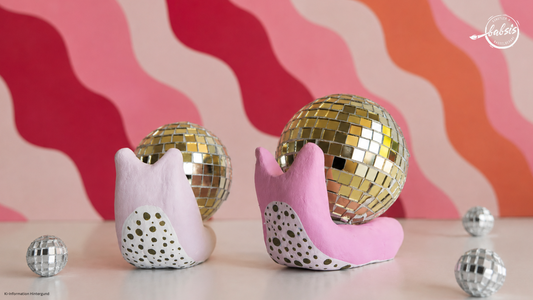 Schnecken aus Modelliermasse pink und rosa mit discokugeln als Schneckenhäuser bunter welliger hintergund