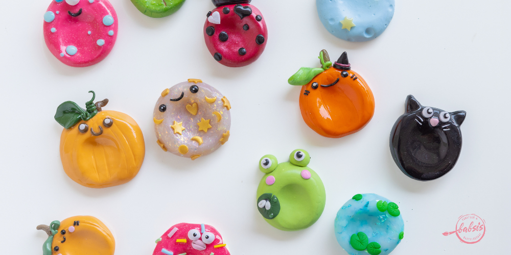 Sorgensteine verschiedene designs auf weißem grund aus polymerclay kürbis katze frosch